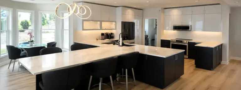 Modern Lake Macatawa kitchen with large island, black cabinets, and contemporary lighting.