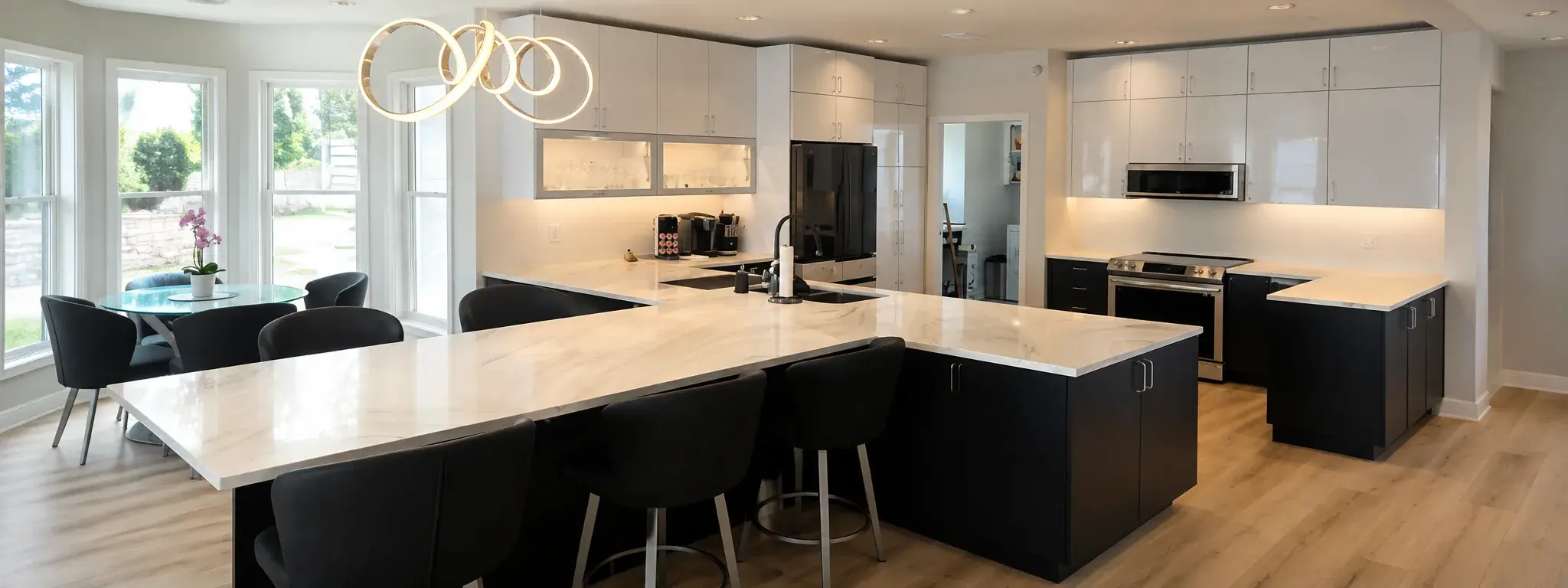 Modern Lake Macatawa kitchen with large island, black cabinets, and contemporary lighting.