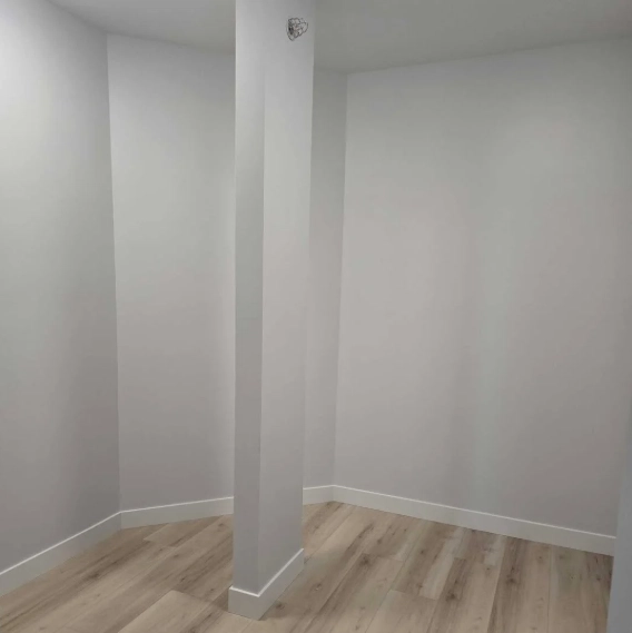 Renovated interior space at a Lake Macatawa home featuring light wood flooring, white walls, and a clean modern layout.