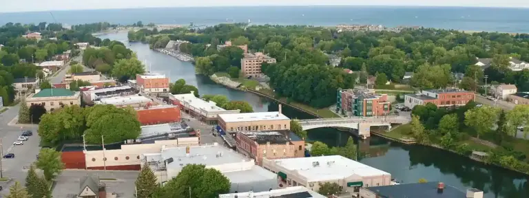 Aerial view of downtown Manistee, Michigan with river, bridge, and Lake Michigan.