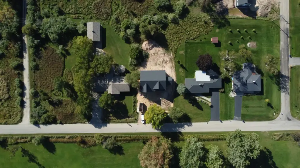 Aerial view of homes, residential lots, and a custom home construction site in West Michigan