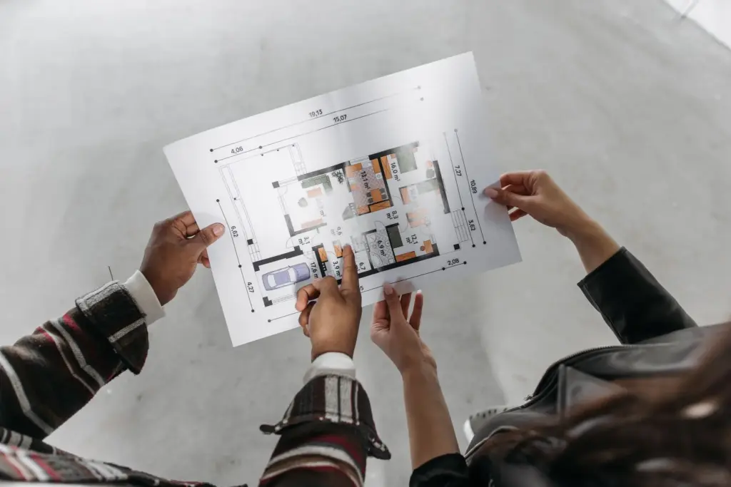 Two people reviewing a custom home floor plan during a planning consultation
