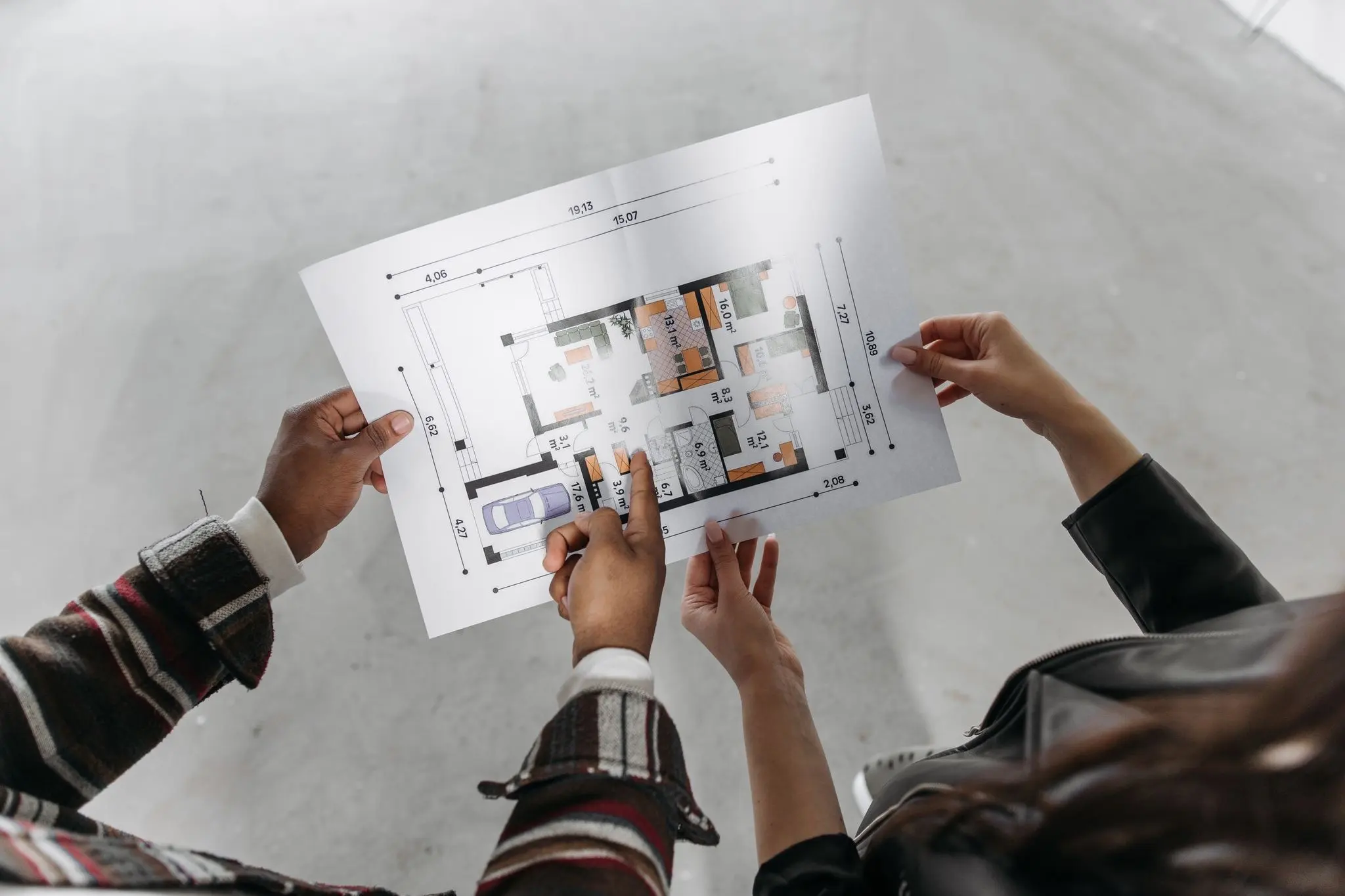 Two people reviewing a custom home floor plan during a planning consultation