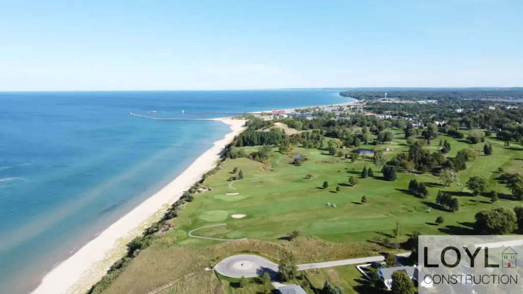 Aerial view of a Michigan lakefront, sandy shoreline, and open land near residential communities