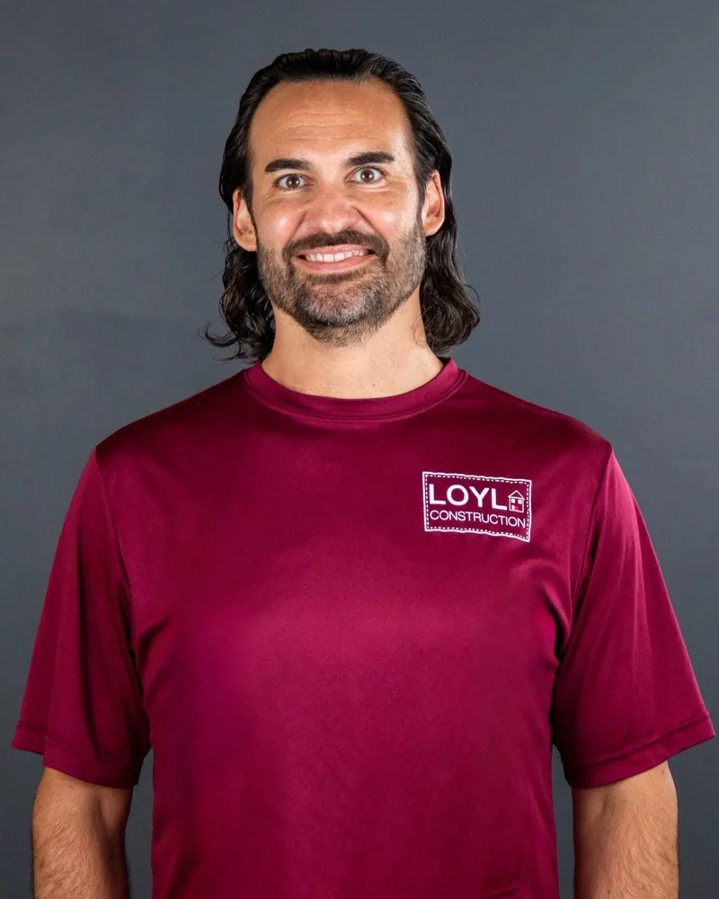 Brad Parisian wearing a branded LOYL Construction shirt against a gray studio background