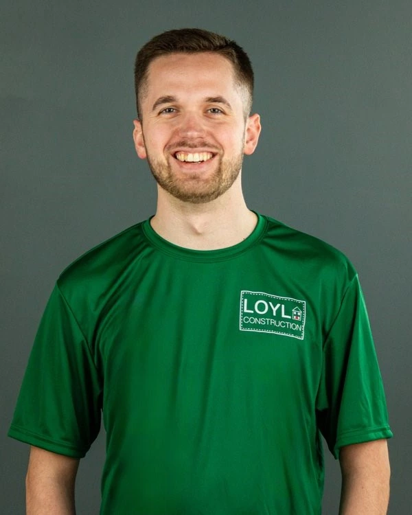 Cody Lang wearing a branded LOYL Construction shirt against a gray studio background