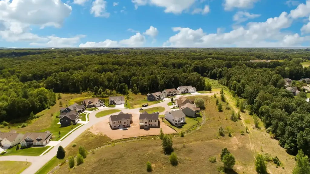 Aerial view of a custom home neighborhood surrounded by wooded land in Western Michigan