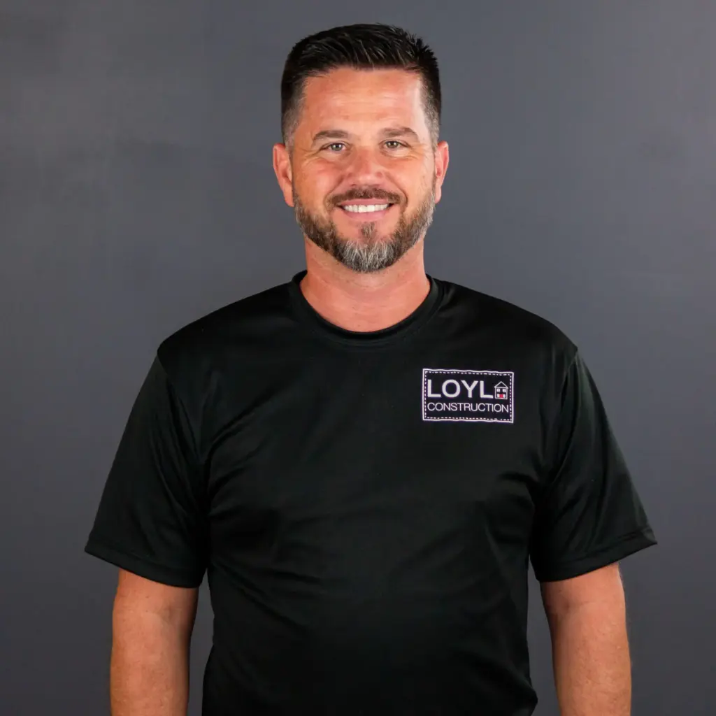 LOYL Construction team member wearing a branded shirt against a gray background