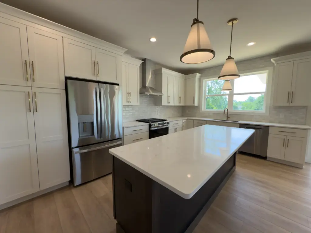 Modern white custom kitchen with island and stainless steel appliances in West Michigan.