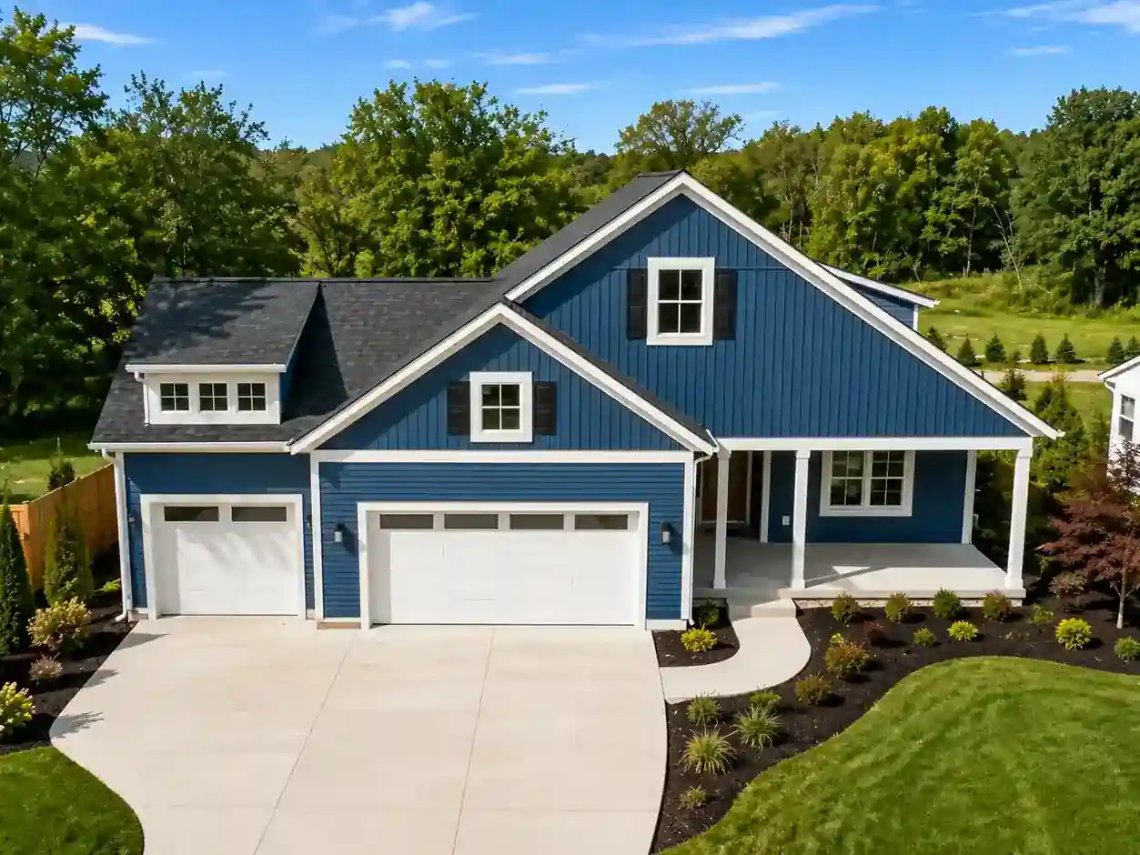 Modern blue custom home with white trim, three-car garage, and landscaped front yard in West Michigan