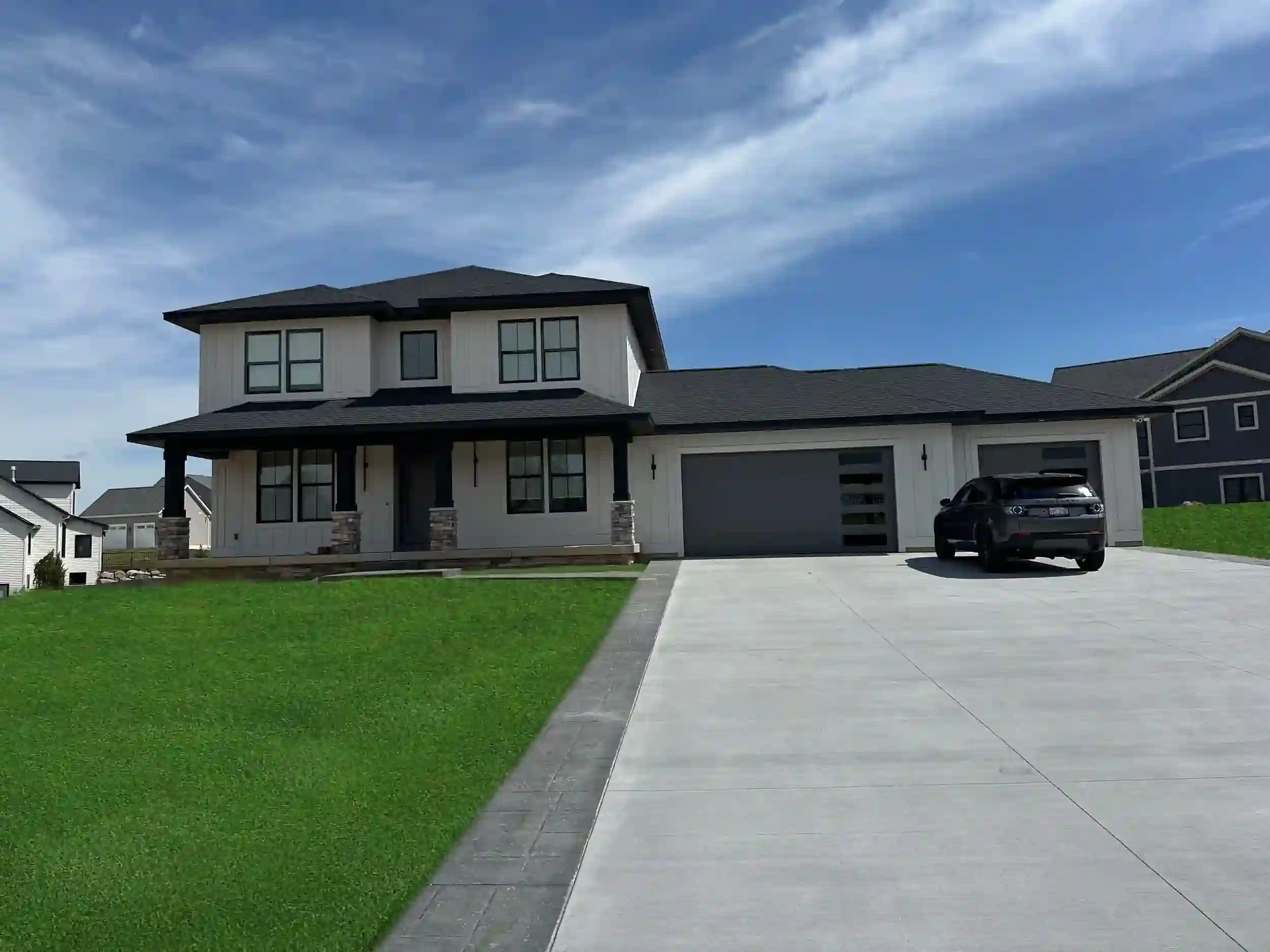 Two-story modern farmhouse with three-car garage in West Michigan.