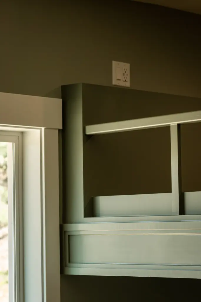 Built-in bunk bed with green millwork, guardrail, and white trim