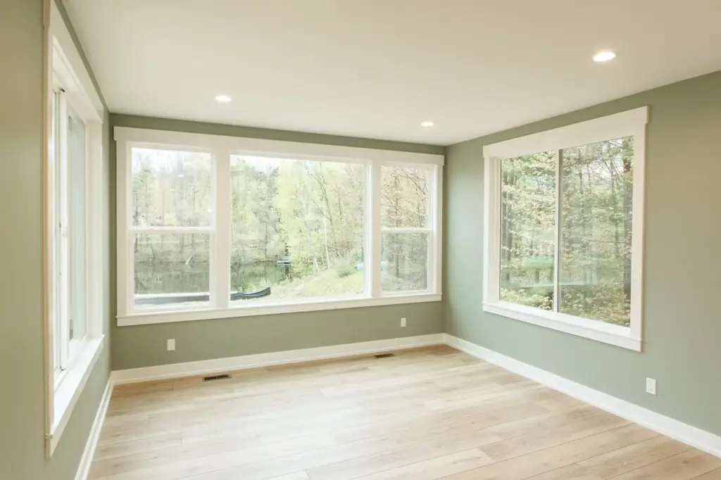 Waterfront home room with large windows overlooking a lake and wooded property