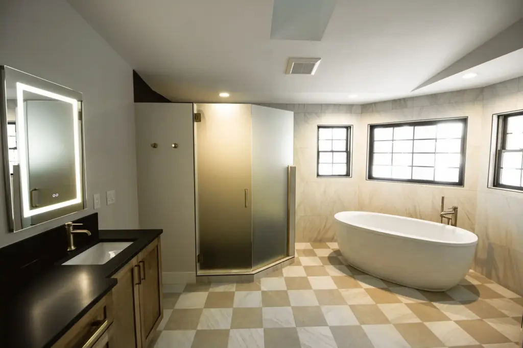 Renovated bathroom with freestanding tub, glass shower, and wood vanity