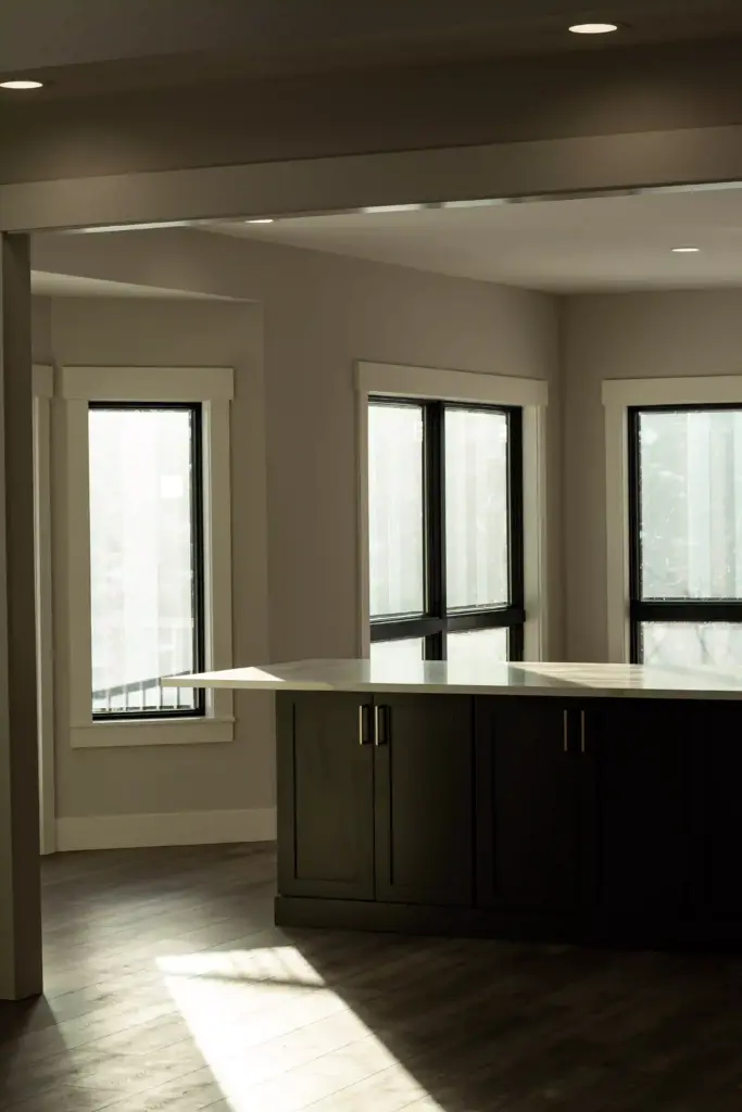 Renovated kitchen with dark island, white countertop, and black-trimmed windows