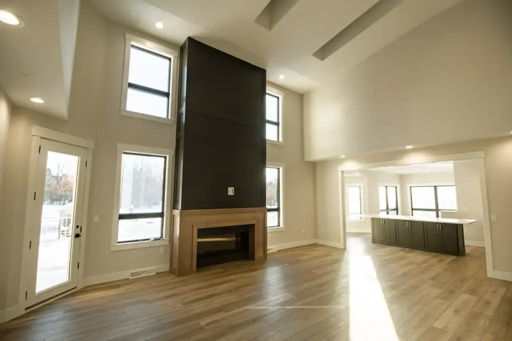 Renovated great room with tall fireplace, large windows, and open kitchen